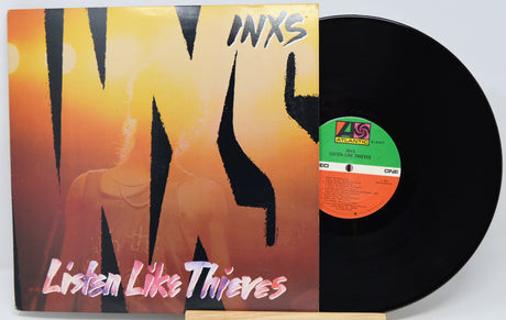 Vinyl record with 'INXS Listen Like Thieves' cover on a white background