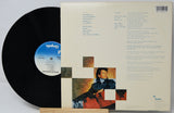 Vinyl record with cover featuring a portrait and text on a light gray background