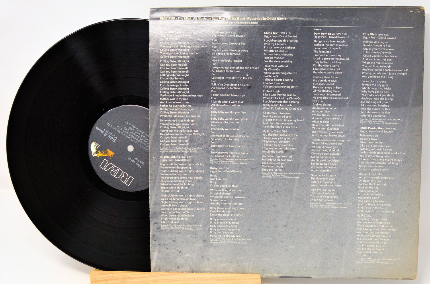 Vinyl record with a clear sleeve displaying track listings on a white background