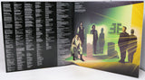 Vinyl record with a black cover featuring text on the left and a colorful album cover on the right with people in a room.