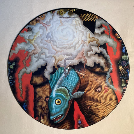 Surreal picture disc with a blue fish and abstract clouds on vivid red background