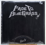A square black album cover for 'Fade To Blue Grass' wrapped in clear plastic, featuring a white stylized logo and text, photographed against a white background.