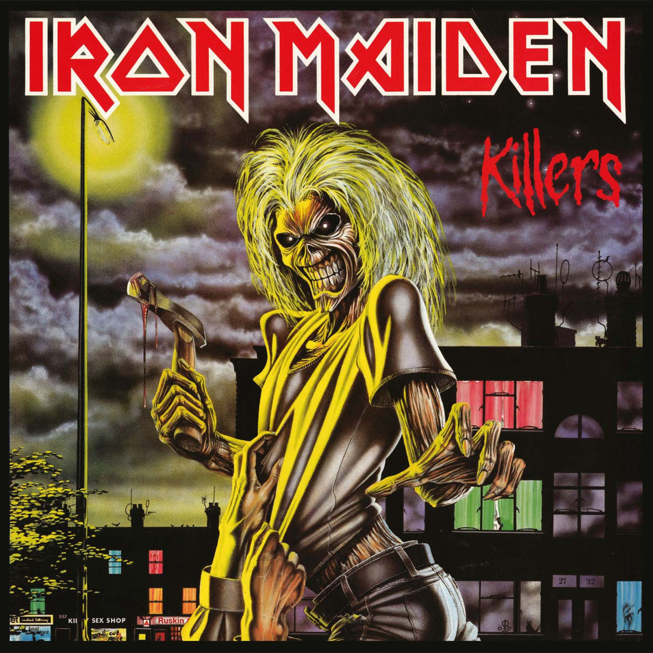 Album cover art for Iron Maiden - Killers featuring a cartoonish illustration of a character with a black and yellow outfit, holding a sword, and screaming, against a dark background with a cityscape.