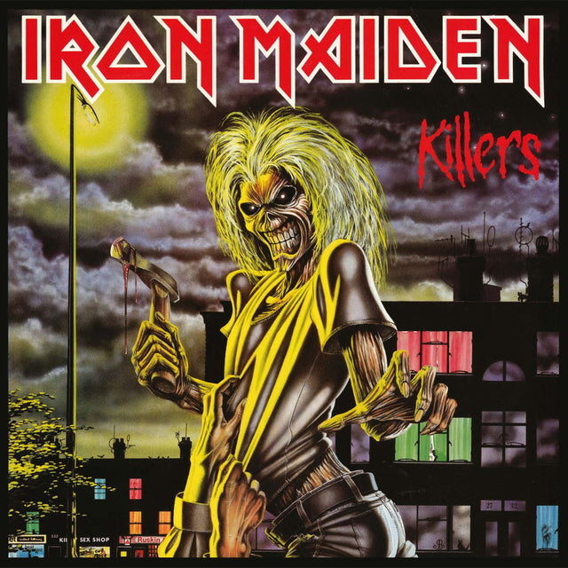 Album cover art for Iron Maiden - Killers featuring a cartoonish illustration of a character with a black and yellow outfit, holding a sword, and screaming, against a dark background with a cityscape.