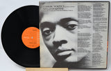 Vinyl record with a black and white portrait on the cover and an orange label.