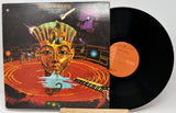 Vinyl record with a colorful cover featuring an Egyptian-style mask and space-themed elements.