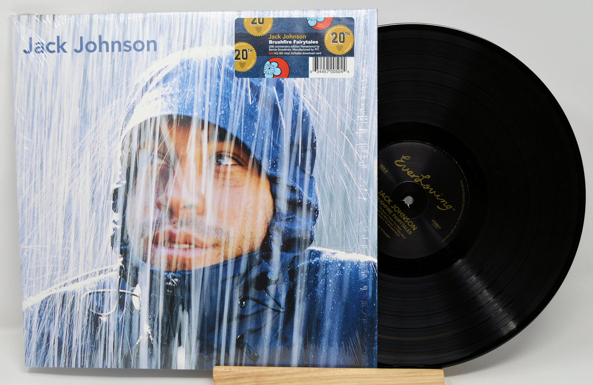 Front cover of Jack Johnson's Brushfire Fairytales 20th anniversary vinyl LP with artist in rain and commemorative sticker