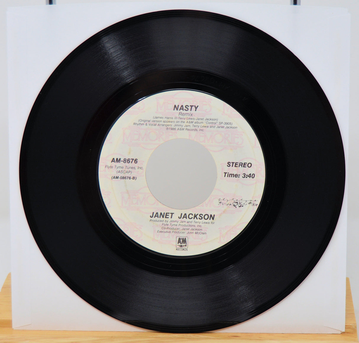 Vinyl record with 'Nasty' by Janet Jackson on a white background