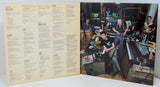 Vinyl record with a cover featuring musicians in a studio setting.