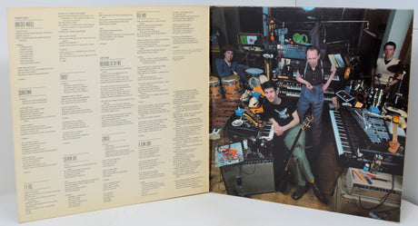 Vinyl record with a cover featuring musicians in a studio setting.