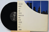 Vinyl record with a cityscape design on the cover