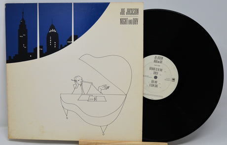 Vinyl record with cover featuring a cityscape and a person at a desk, titled 'Night and Day' by Joe Jackson.