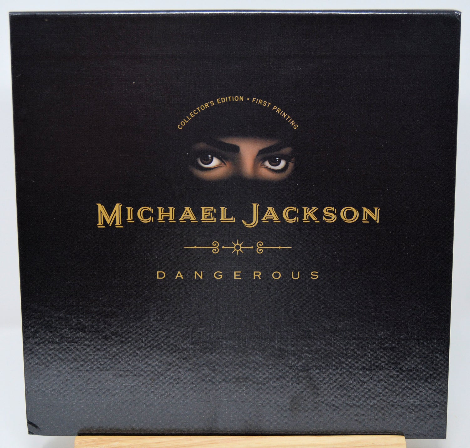 Black album cover with 'Michael Jackson Dangerous' and a face peeking over the top.