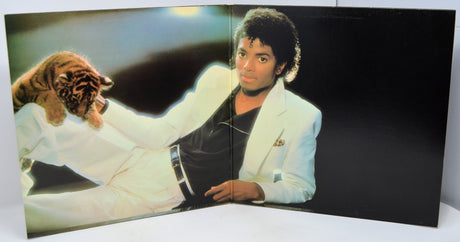 Album cover with a person in a white jacket and tiger, on a black background