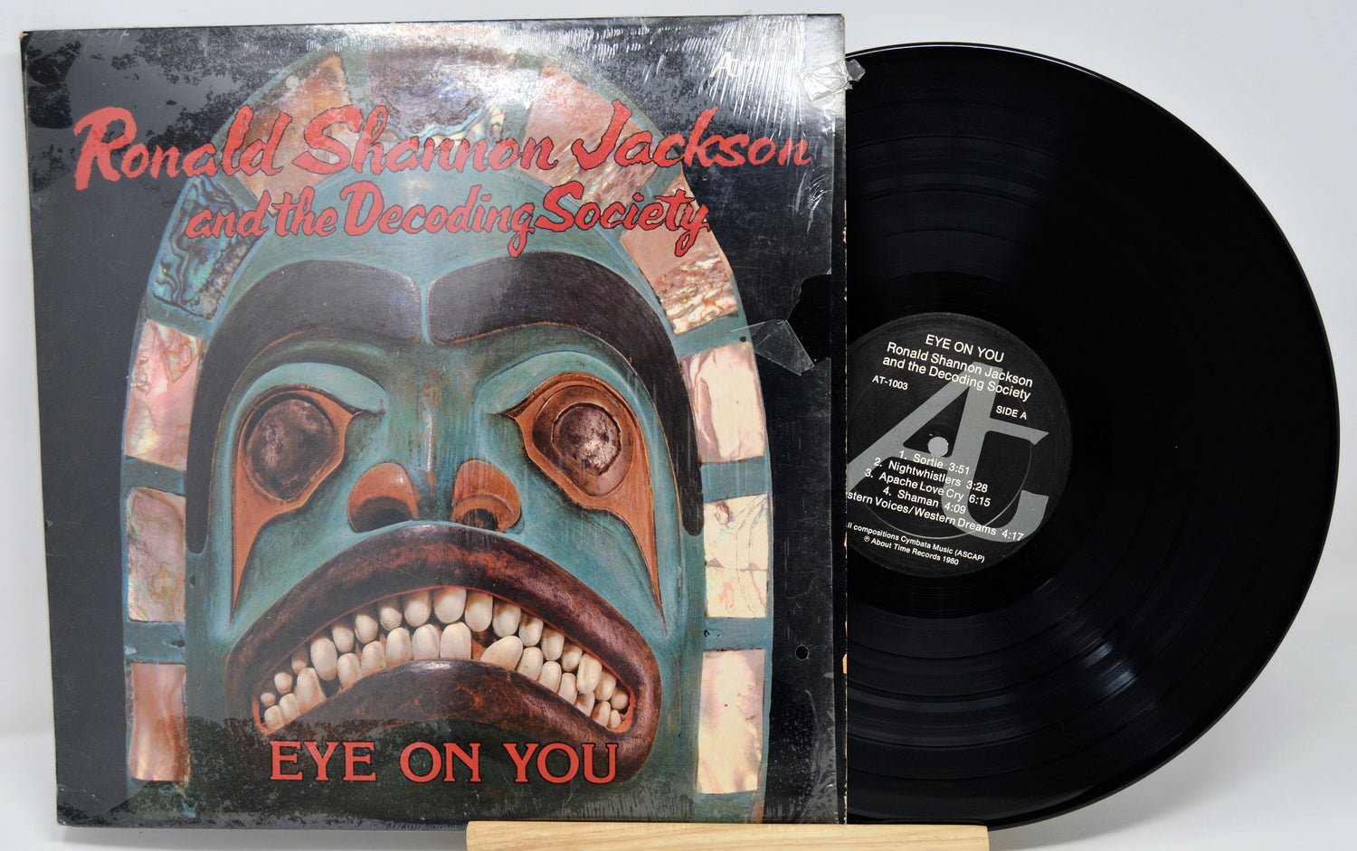 Vinyl record with cover featuring a stylized face design and text.