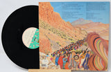 Vinyl record with a colorful album cover depicting a desert scene and people.