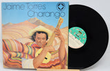 Vinyl record with cover featuring a person playing a charango in a colorful setting