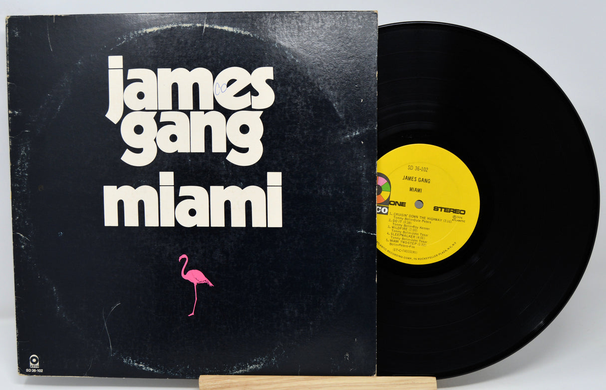 Vinyl record and cover with 'James Gang Miami' text and a pink flamingo on a black background.