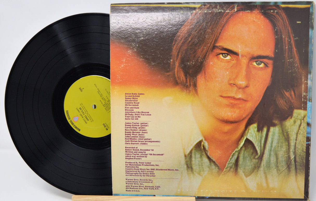 Vinyl record 'James Taylor Sweet Baby James'  with back cover featuring a person's face on a white background