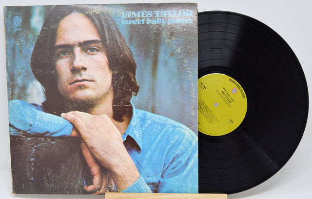 Vinyl record 'James Taylor Sweet Baby James'  with cover featuring a person, on a white background