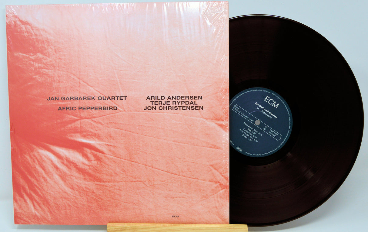 Front cover of Jan Garbarek Quartet Afric Pepperbird vinyl LP featuring minimalist pink design and member names