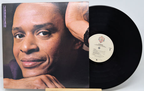 Vinyl record with a cover featuring a person's face on a white background