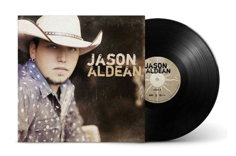 A vinyl record and its album cover for Jason Aldean's 'This Ain't No Nuthin' But a Thug' are shown on a white background. The cover features a portrait of the artist in a cowboy hat, and the black vinyl record is partially pulled out, showing the label.