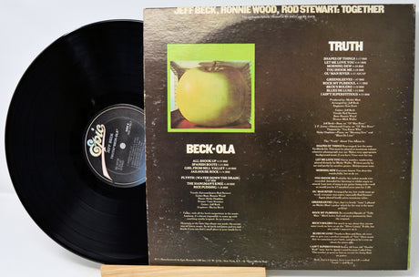Vinyl record with its cover displaying text and an image of a green apple.