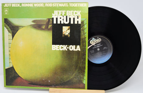Vinyl record with green cover featuring an apple and text, on a white background