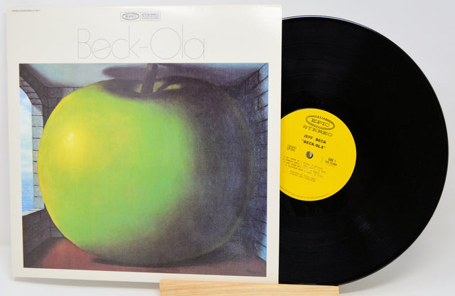 Jeff Beck's 'Beck-Ola' vinyl record LP shown with its album cover sleeve and the black record partially pulled out, displaying the yellow center label.