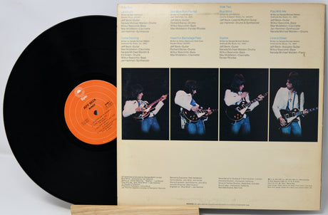 Vinyl record with a black label and a colorful inner sleeve featuring images of a person playing guitar.