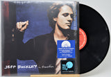 Jeff Buckley 'in transition' vinyl record album with the LP partially pulled from its jacket, showing the black record, cover art, a blue limited edition sticker, and a We Are Vinyl sticker on a light gray background.