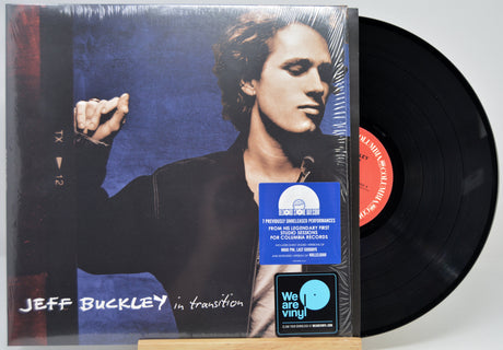 Jeff Buckley 'in transition' vinyl record album with the LP partially pulled from its jacket, showing the black record, cover art, a blue limited edition sticker, and a We Are Vinyl sticker on a light gray background.