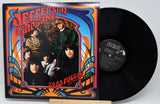 Vinyl record with colorful cover featuring a band and text