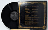 Vinyl record with gold and black cover displaying tracklist on a white background