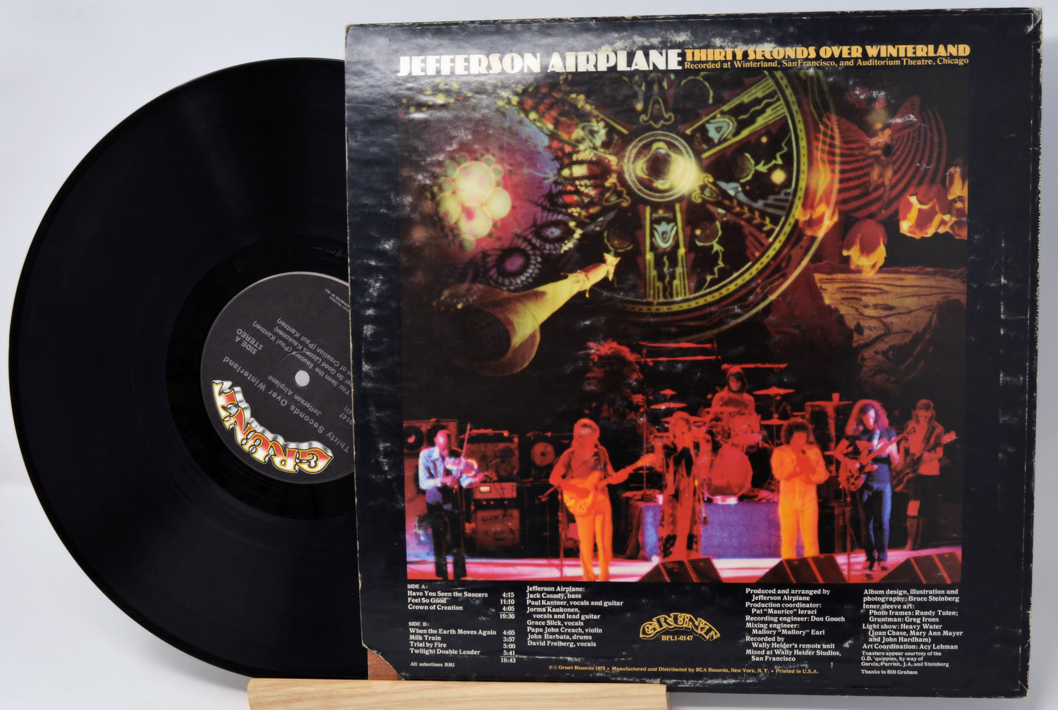 Vinyl record with cover featuring a band on stage and space-themed artwork.