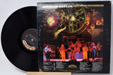 Vinyl record with cover featuring a band on stage and space-themed artwork.