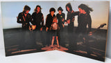 Album cover with a band posing on a stage