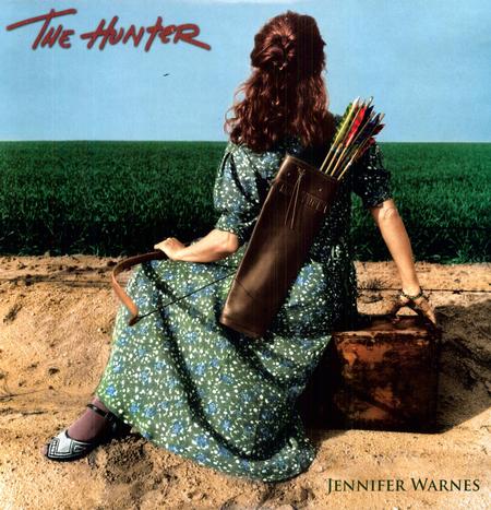 Album cover for 'The Hunter' by Jennifer Warnes, featuring a woman in a green floral dress sitting on a dirt mound with a bow and arrow quiver on her back, set against a field and blue sky.