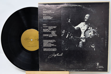 Vinyl record with a black and white cover featuring a person playing an instrument.