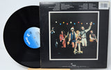 Vinyl record with a cover featuring a band and colorful lights on a white background