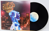 Vinyl record with a colorful cover featuring a person in a blue suit against a cityscape.