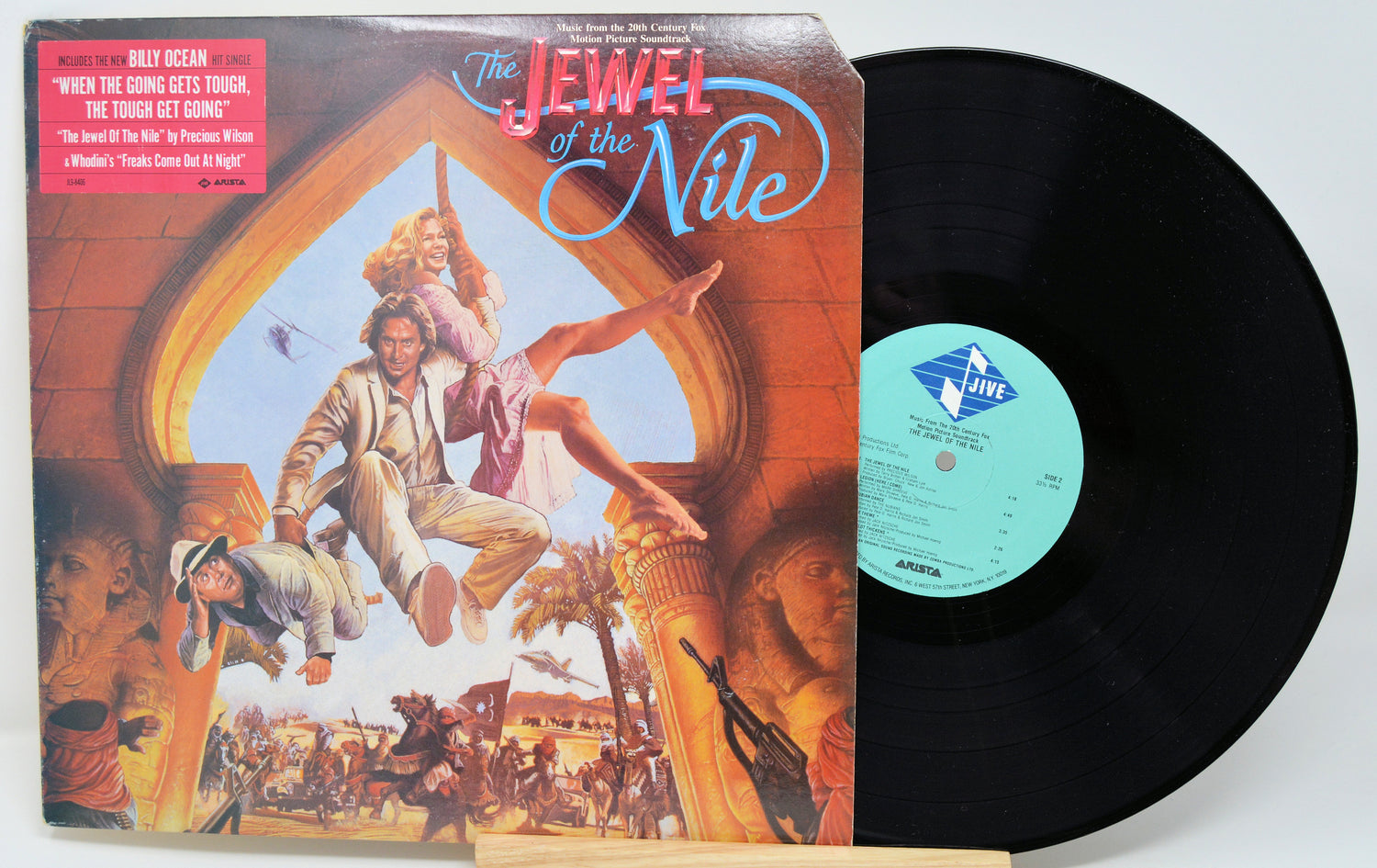 Vinyl record with colorful cover featuring people and text, on a white background