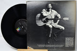 Vinyl record with a black and white photo of a person playing guitar on the cover