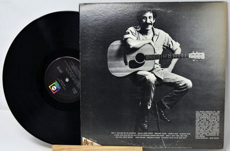 Vinyl record with a black and white photo of a person playing guitar on the cover
