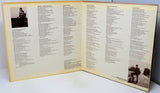 Open book with text and two black and white photos on a white surface
