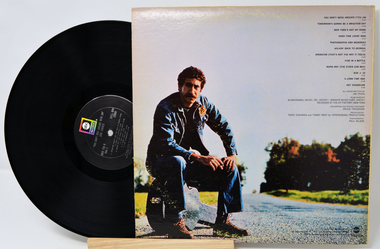 Vinyl record with cover featuring a person sitting on a road.