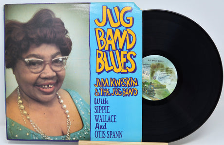 A vinyl record album titled 'Jug Band Blues' by Jam Kweskin & The Jug Band, shown with the printed cover sleeve and a black record partially pulled out. The cover features a portrait of a smiling woman on the left and a bright blue center panel with yellow and white title text.