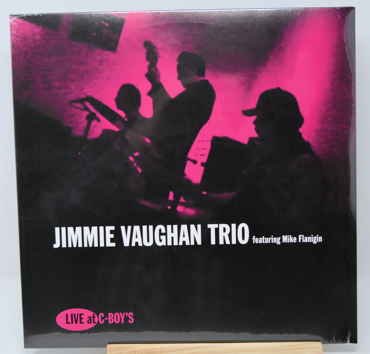 Album cover of Jimmie Vaughan Trio featuring Mike Flannigan with silhouettes against a pink light.