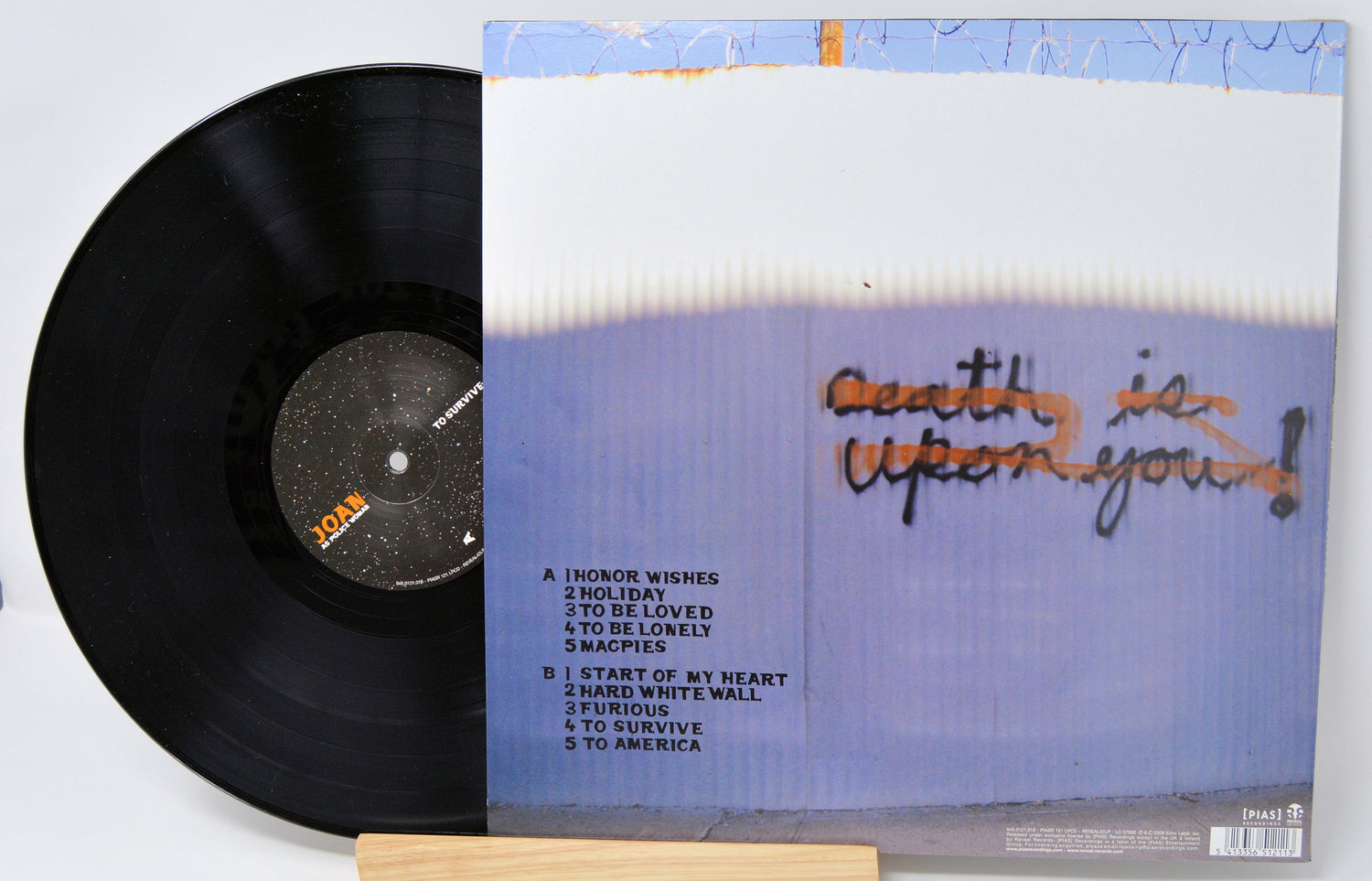 Back cover and vinyl record of Joan As Police Woman's 'To Survive' album with tracklist and graffiti